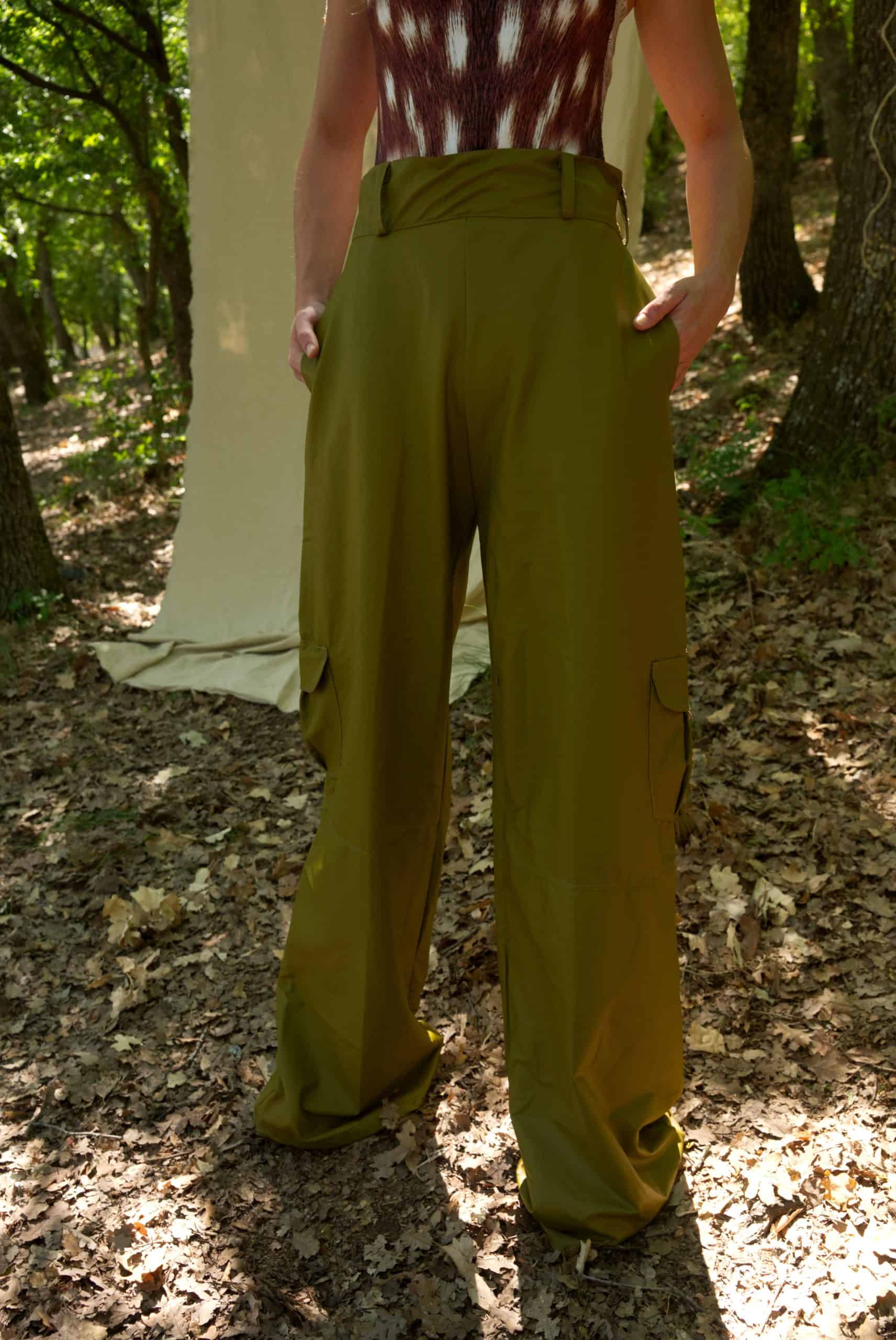 Person wearing green wide-leg pants in a forest setting