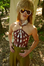 Person wearing a patterned halter top and sunglasses outdoors