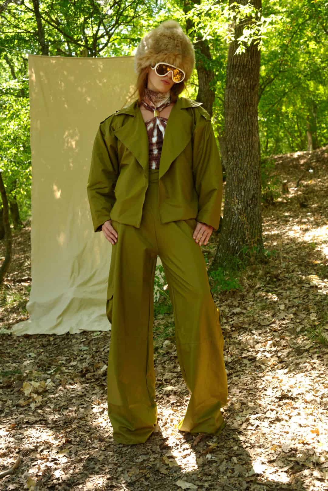 Person wearing a green trench coat and pants in a forest setting