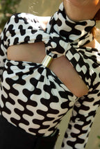 Black and white patterned top with a large bow detail.