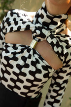 Black and white patterned top with a large bow detail.