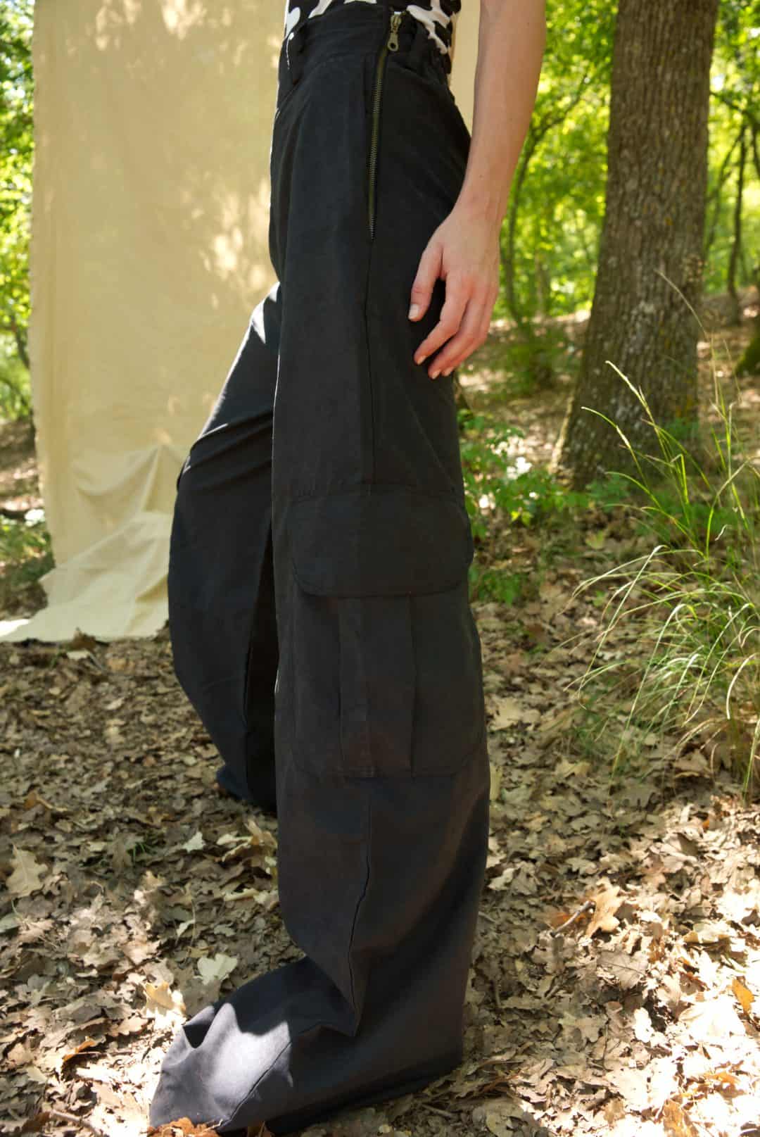 Person wearing a long black skirt in a forest setting