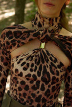 Person wearing a leopard print top with a forest background