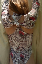 Person wearing a patterned swimsuit with a neutral background