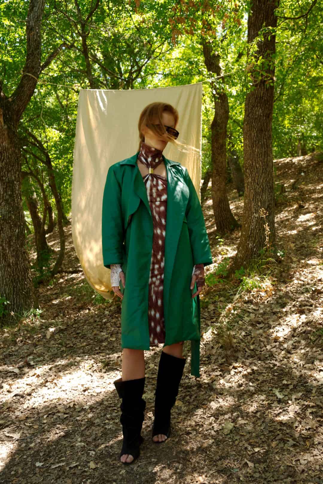 Person wearing a green coat in a forest setting