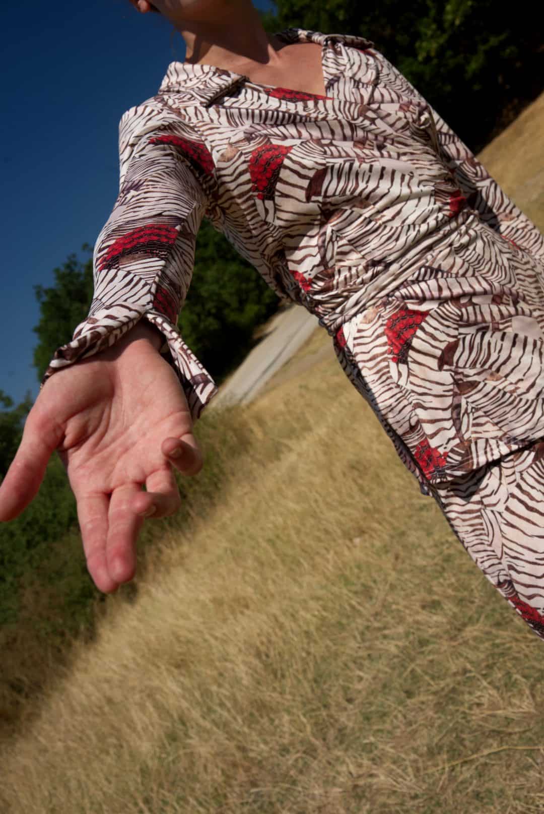 Person wearing a patterned shirt with a blurred background