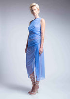 Woman wearing a light blue dress with a draped design on a plain background