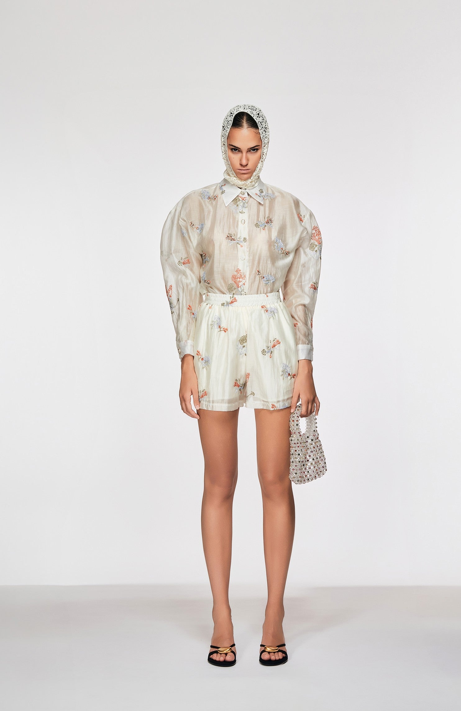 Woman wearing a floral outfit with a headscarf on a white background