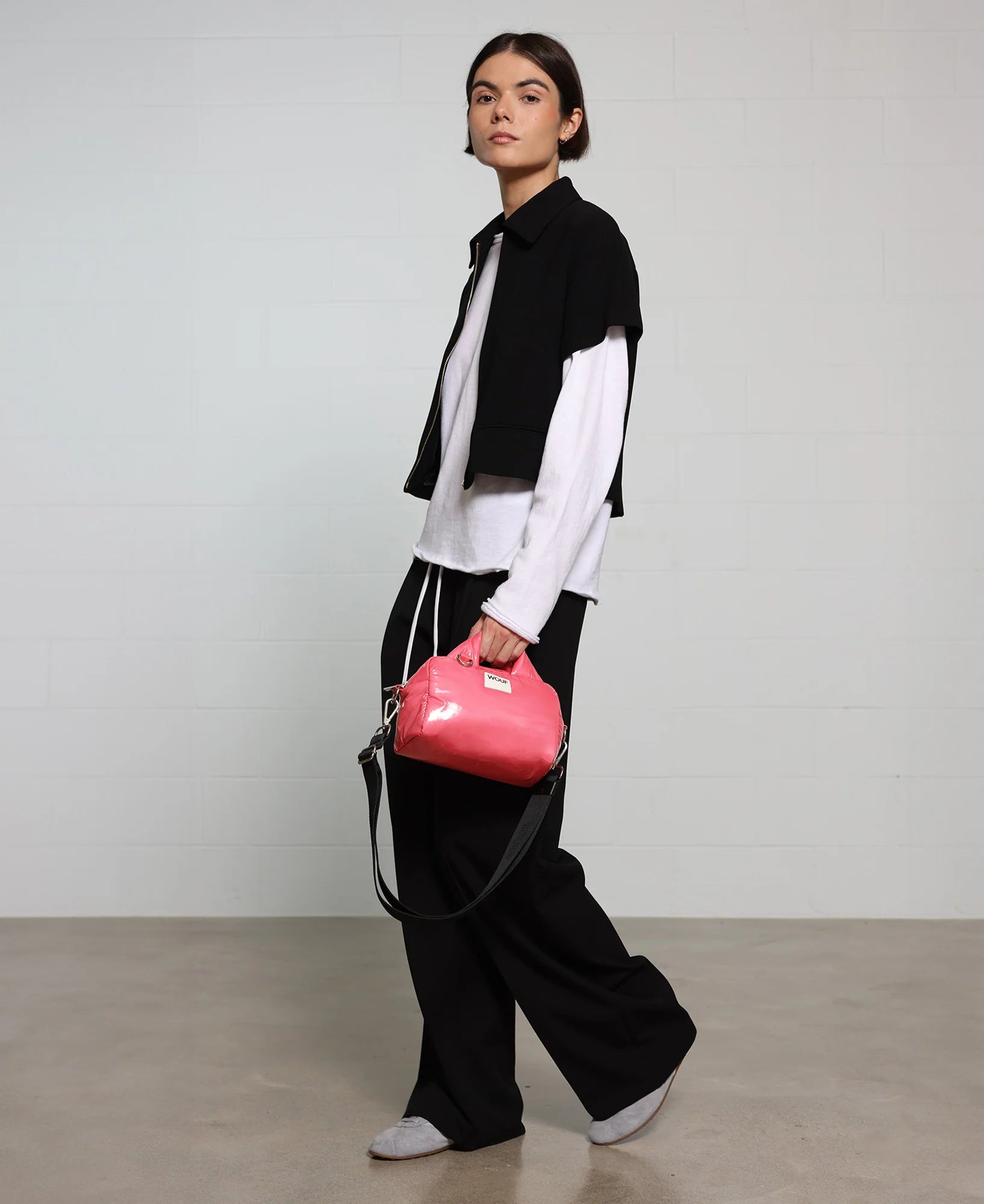 Person holding a pink handbag against a plain background