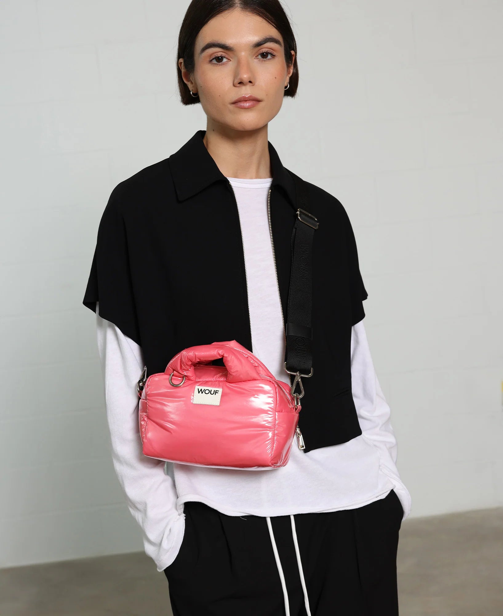 Person holding a pink bag with a neutral background