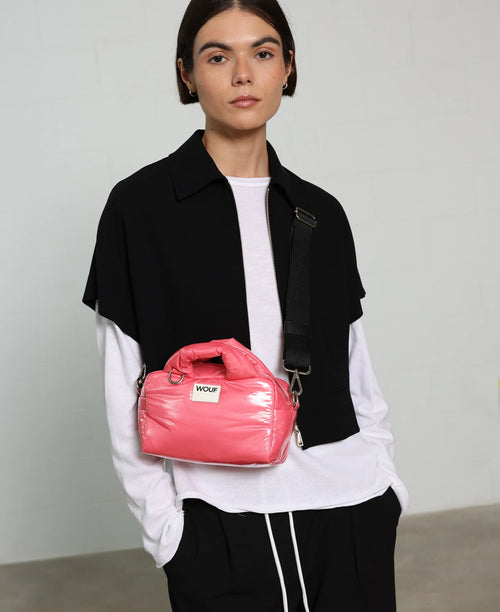 Person holding a pink bag with a neutral background