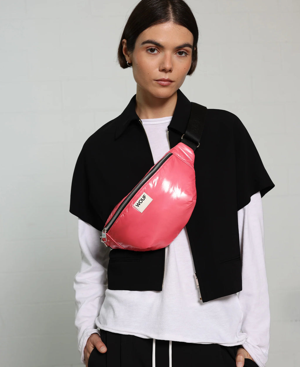 Person wearing a pink waist bag with a neutral background