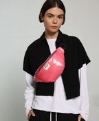 Person wearing a pink waist bag with a neutral background