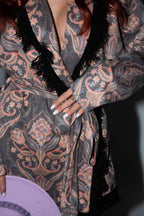 Person wearing a patterned robe with a dark background