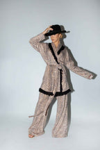 Person wearing a patterned outfit with black trim on a white background