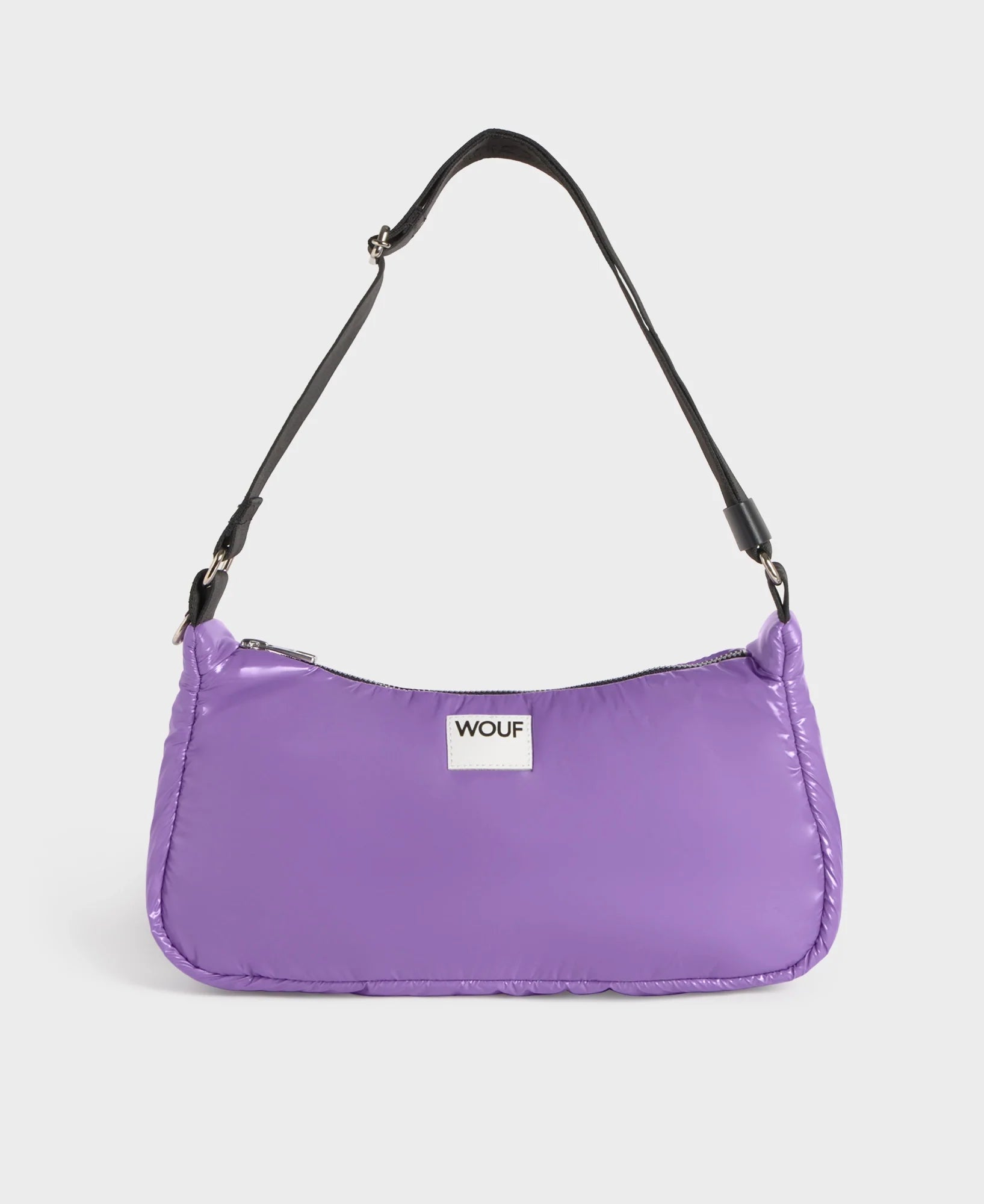Purple handbag with a black strap on a light gray background