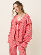Woman wearing a red checkered outfit on a beige background