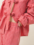 Red and white checkered outfit with ruffled sleeves on a neutral background