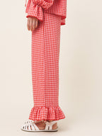 Red and white checkered dress with ruffled details on a plain background