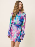 Woman wearing a colorful tie-dye outfit on a beige background