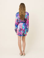 Woman wearing a colorful dress with a plain background