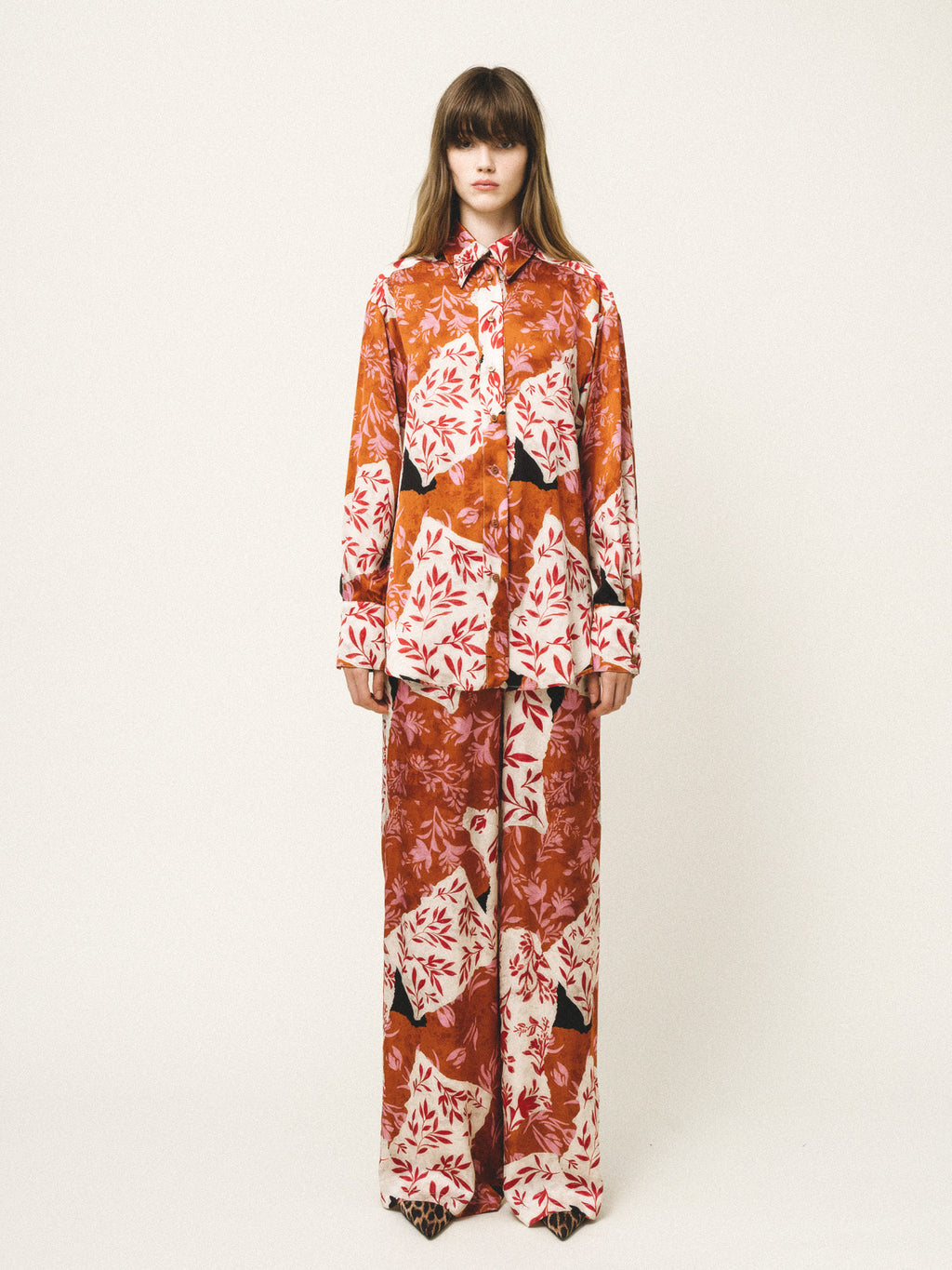 Model wearing a floral patterned outfit on a white background