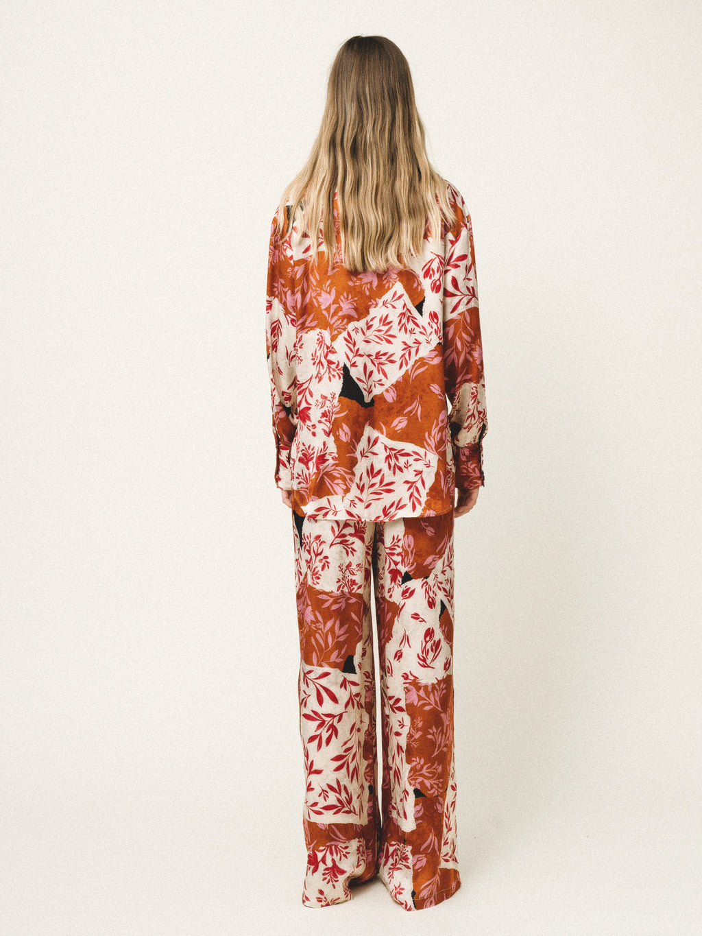 Person wearing a floral pajama set on a white background