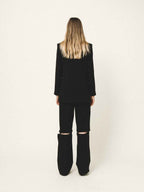 Person wearing a black outfit with a white background