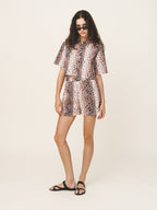 Woman wearing a leopard print outfit on a white background