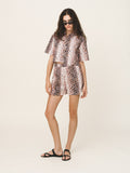 Woman wearing a leopard print outfit on a white background