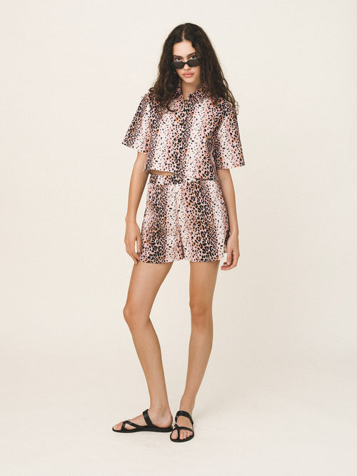 Woman wearing a leopard print outfit on a white background