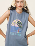 Woman wearing a blue sleeveless shirt with a palm tree and sunset design.