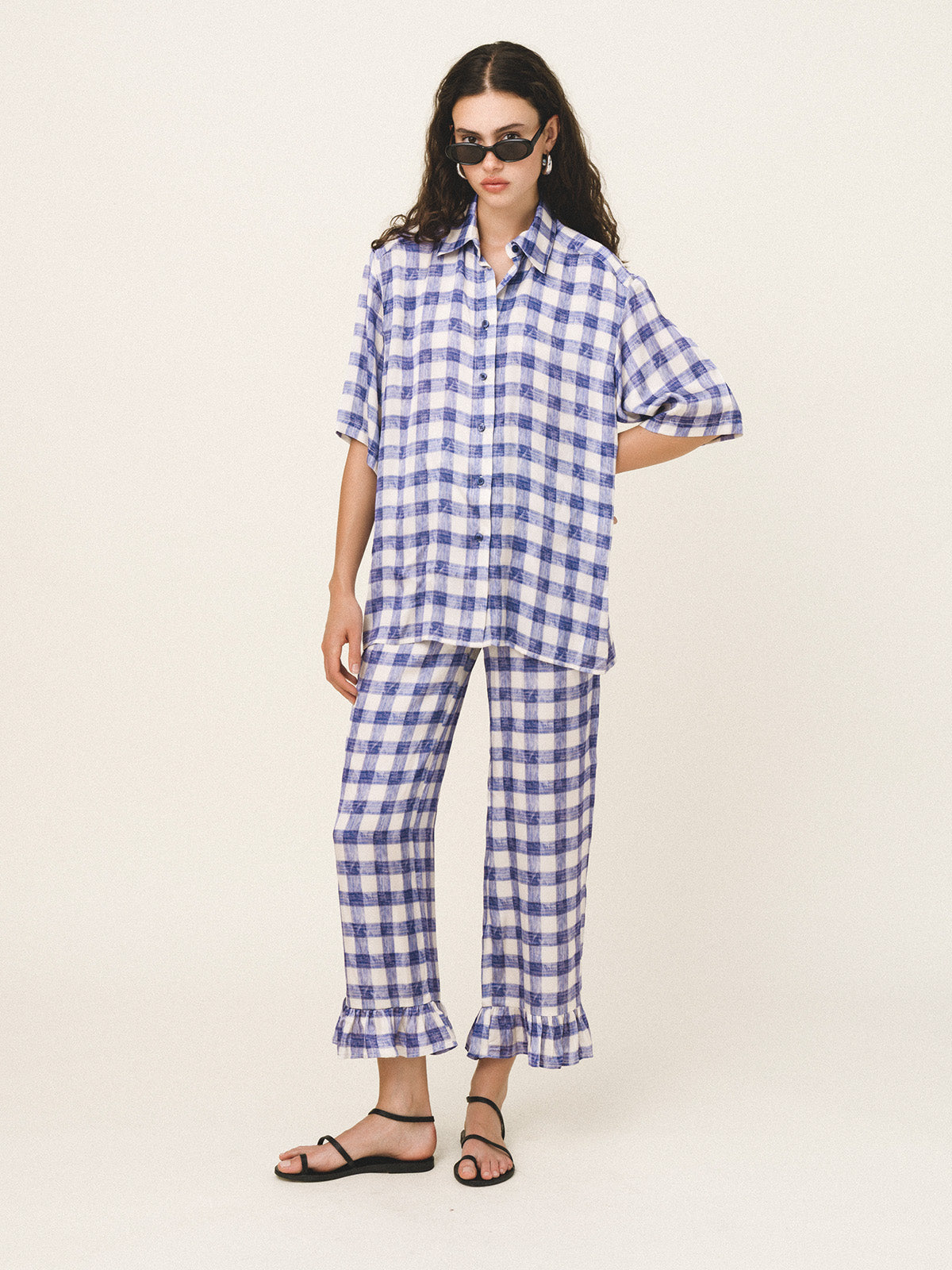 Woman wearing a blue and white checkered outfit on a white background