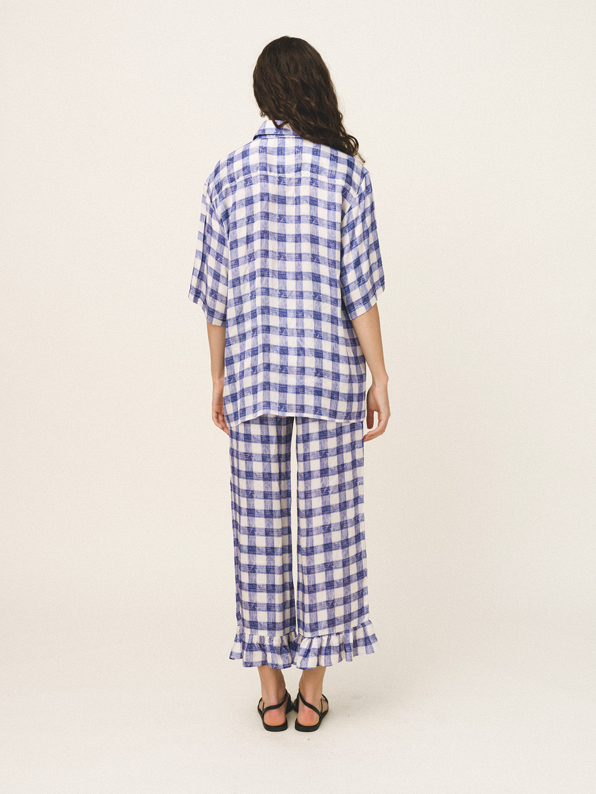 Woman wearing a blue and white checkered outfit on a white background