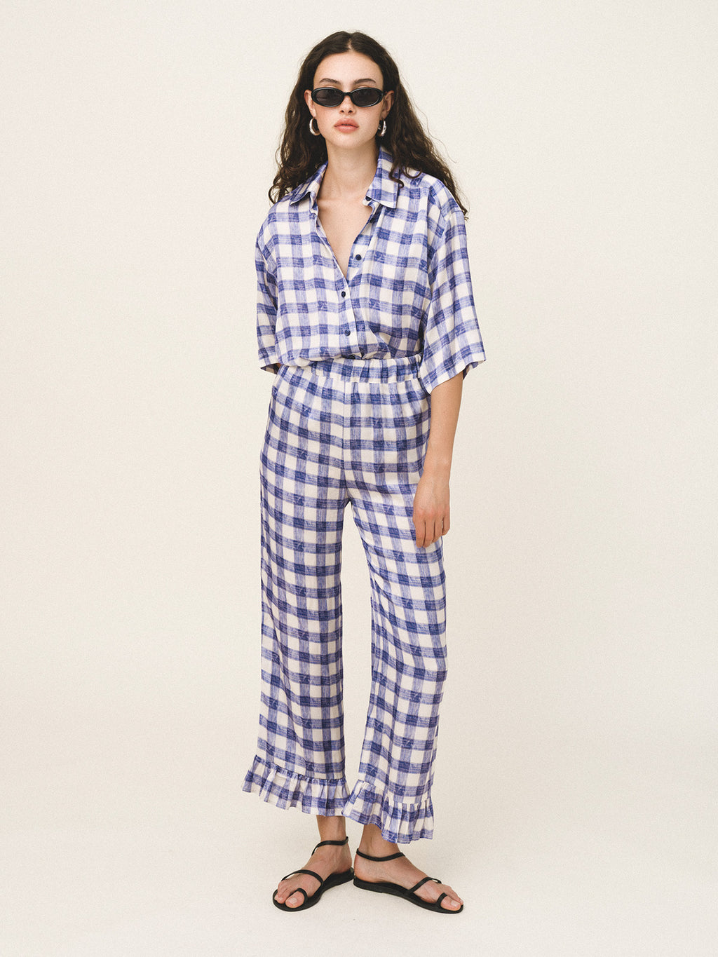 Woman wearing a blue and white checkered outfit on a plain background