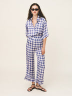 Woman wearing a blue and white checkered outfit on a plain background