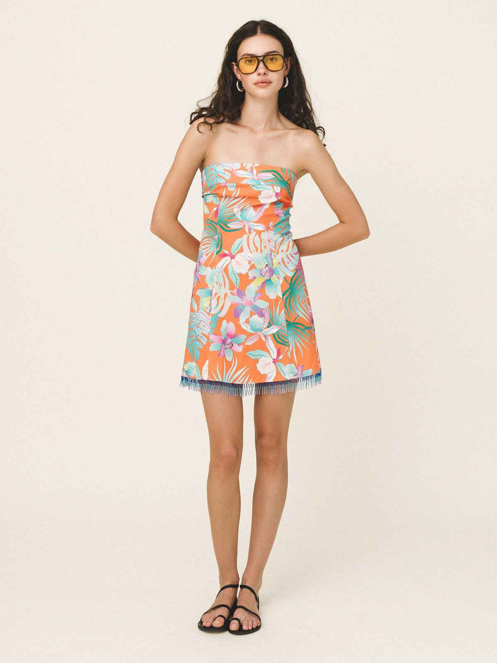 Woman wearing a strapless floral dress on a white background