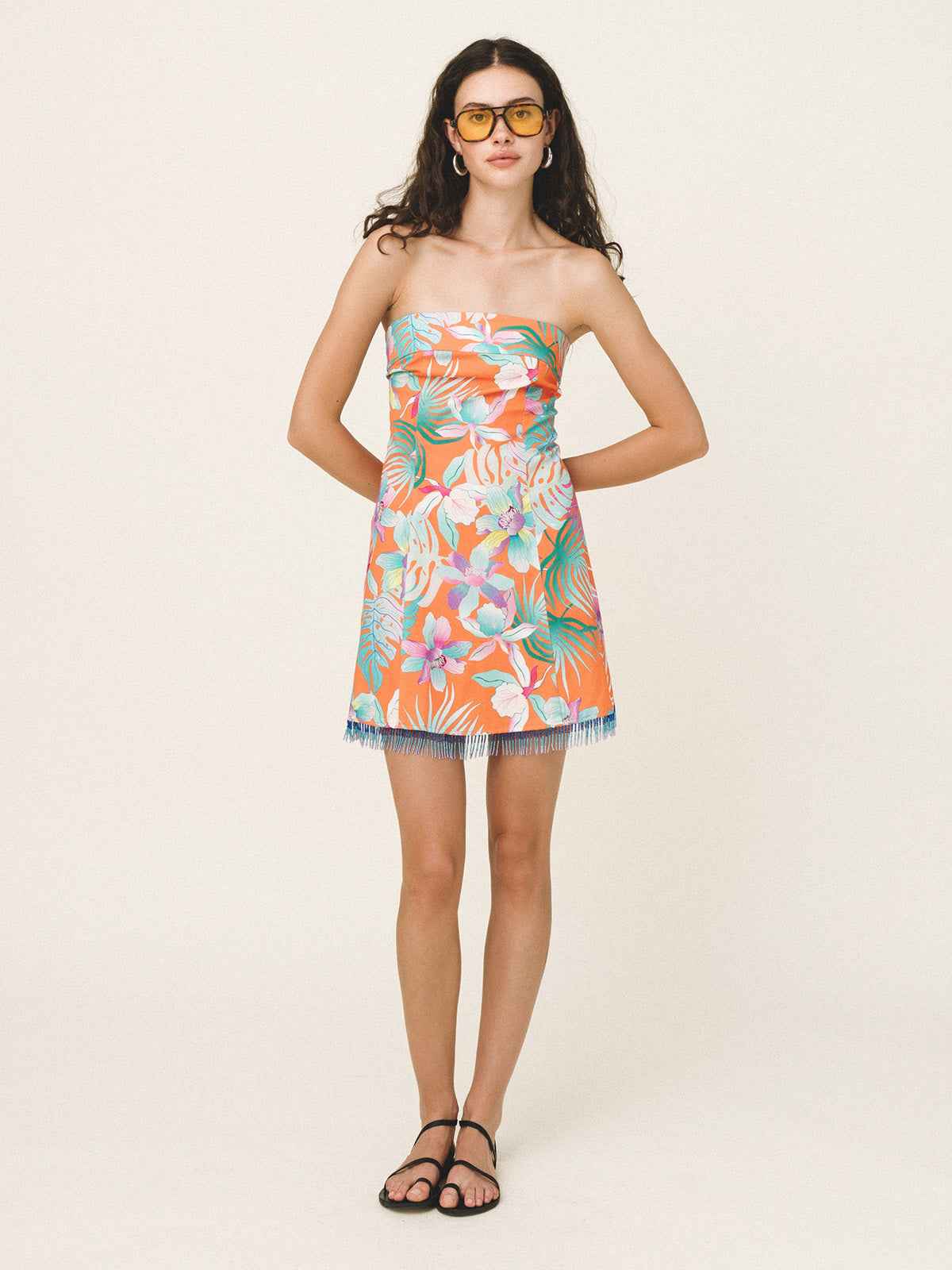 Woman wearing a strapless floral dress on a white background