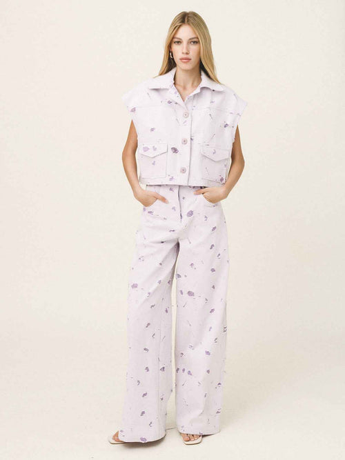 Woman wearing a light purple outfit with a vest and pants on a white background