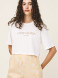 Woman wearing a white t-shirt with 'LOVE ALICIA' text on a beige background