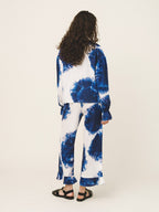 Person wearing a blue and white tie-dye outfit on a plain background