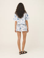 Woman wearing a floral outfit on a plain background