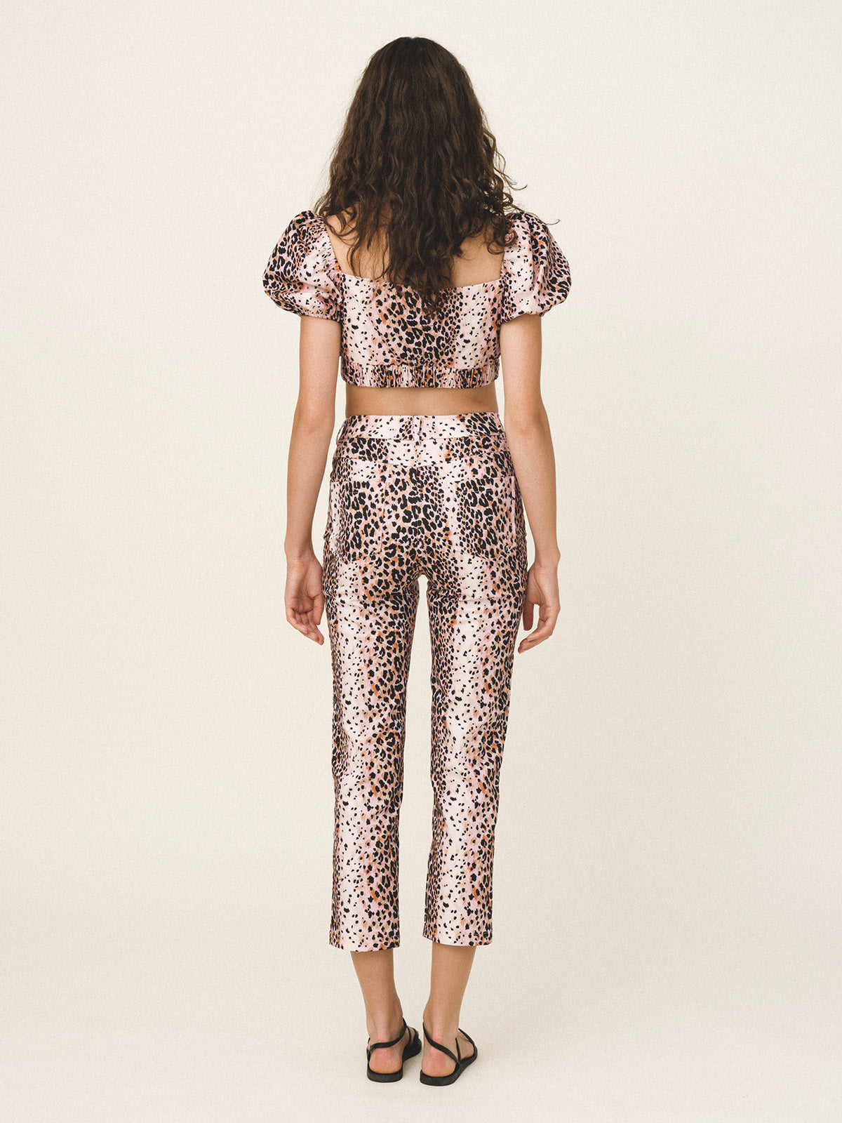 Person wearing a leopard print outfit on a white background