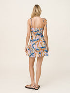 Woman wearing a patterned dress on a plain background