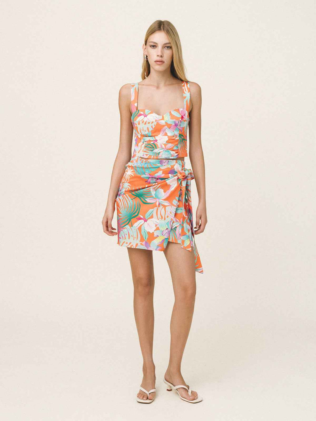 Woman wearing a colorful floral dress on a white background