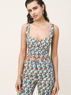 Woman wearing a colorful patterned jumpsuit on a plain background