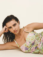 Woman wearing a floral dress against a plain background