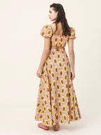 Woman wearing a sunflower patterned dress on a plain background