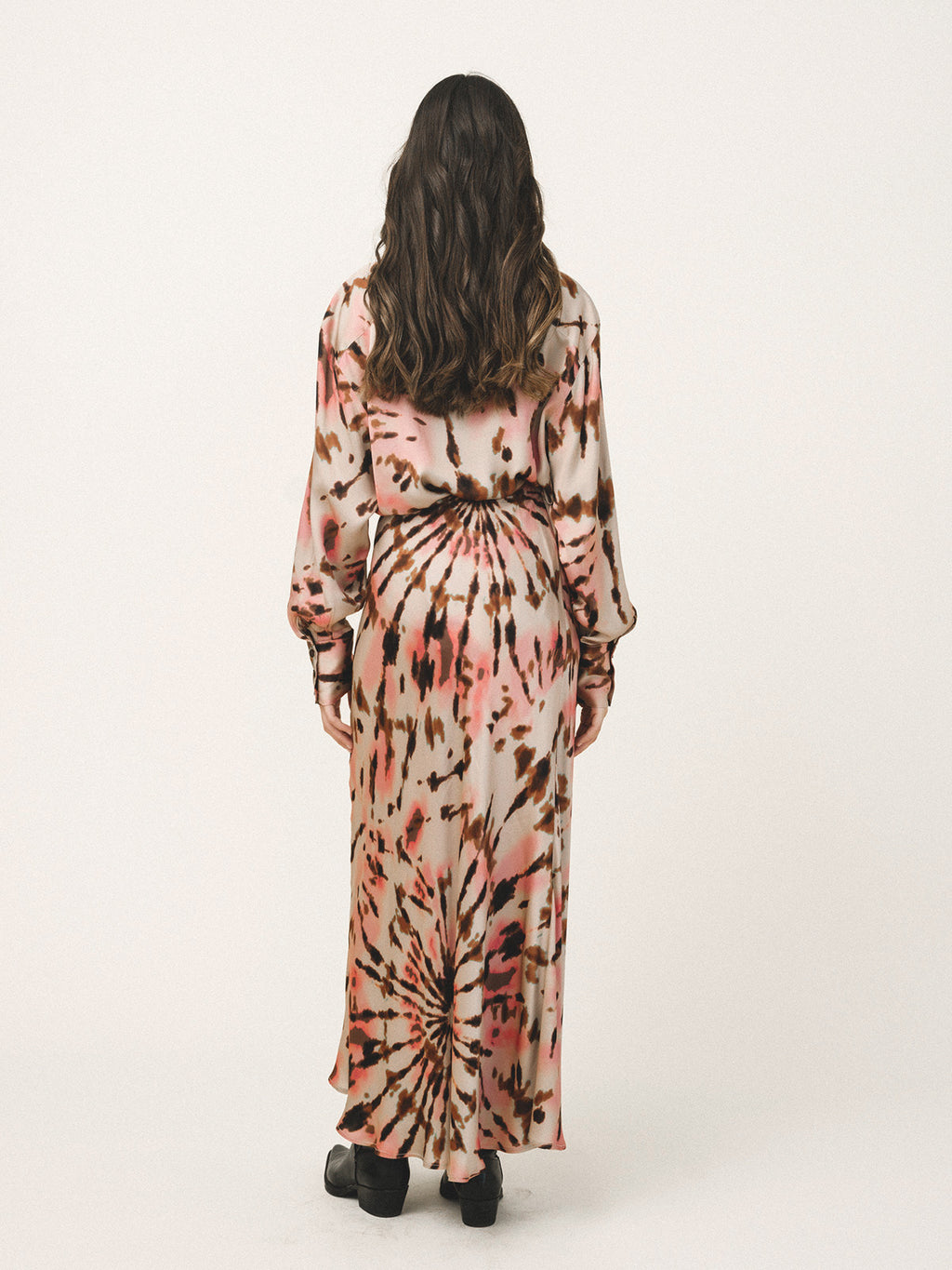 Person wearing a tie-dye dress with a white background