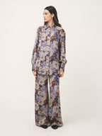 Woman wearing a floral patterned outfit on a white background